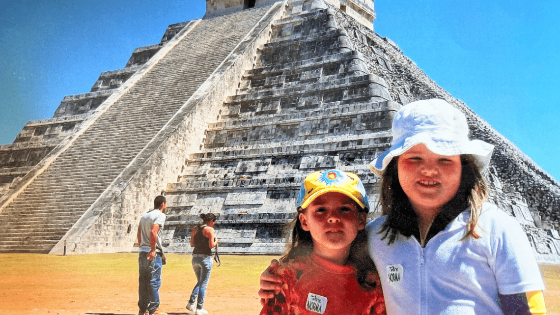 two young girls in front of chicken itza ruins in Mexico.