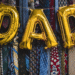dad balloons and a tie themed banner behind them