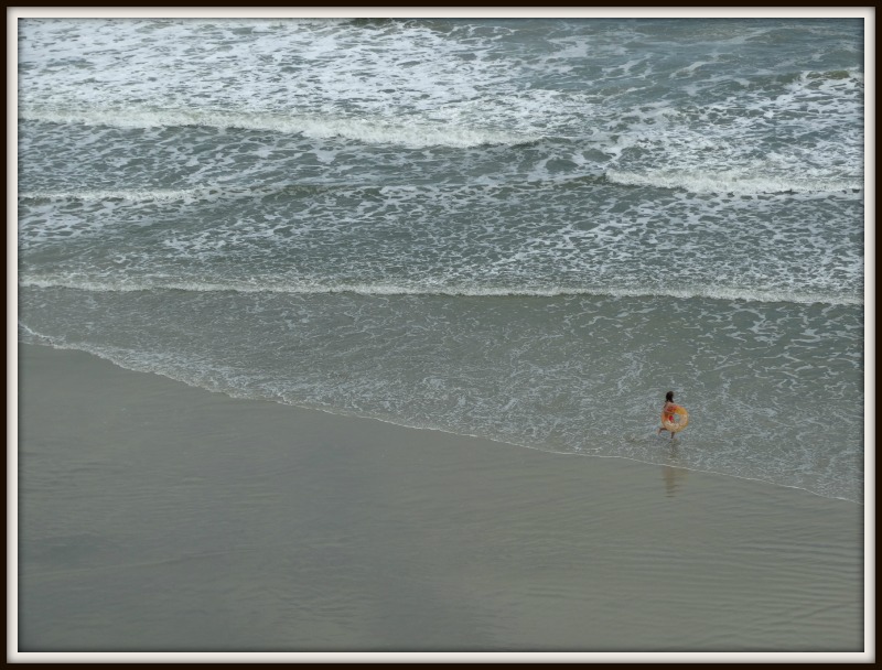 Daytona Beach shore with a child playing near water's edge