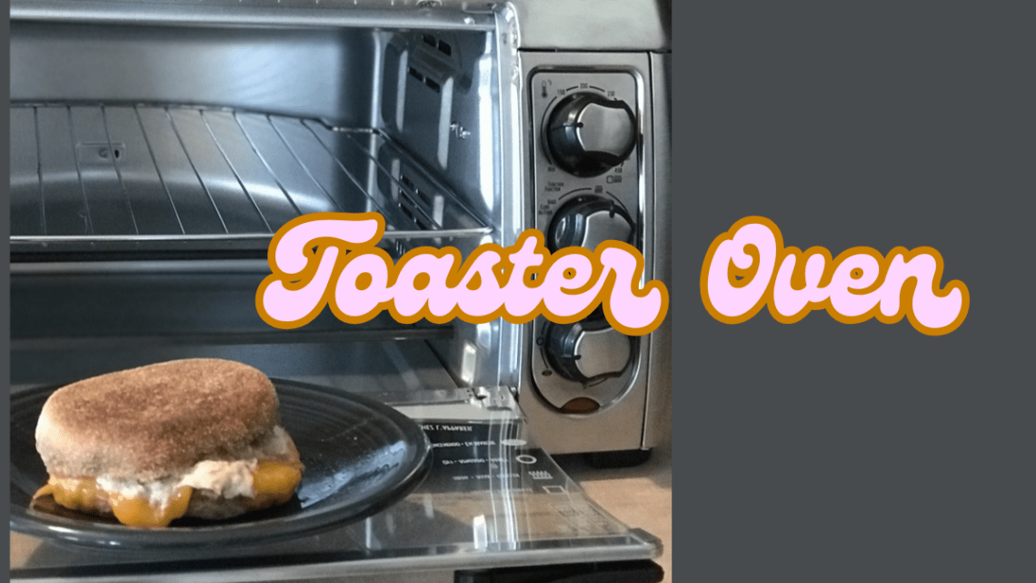 tuna melt in front of a stainless steel toaster oven on a grey background