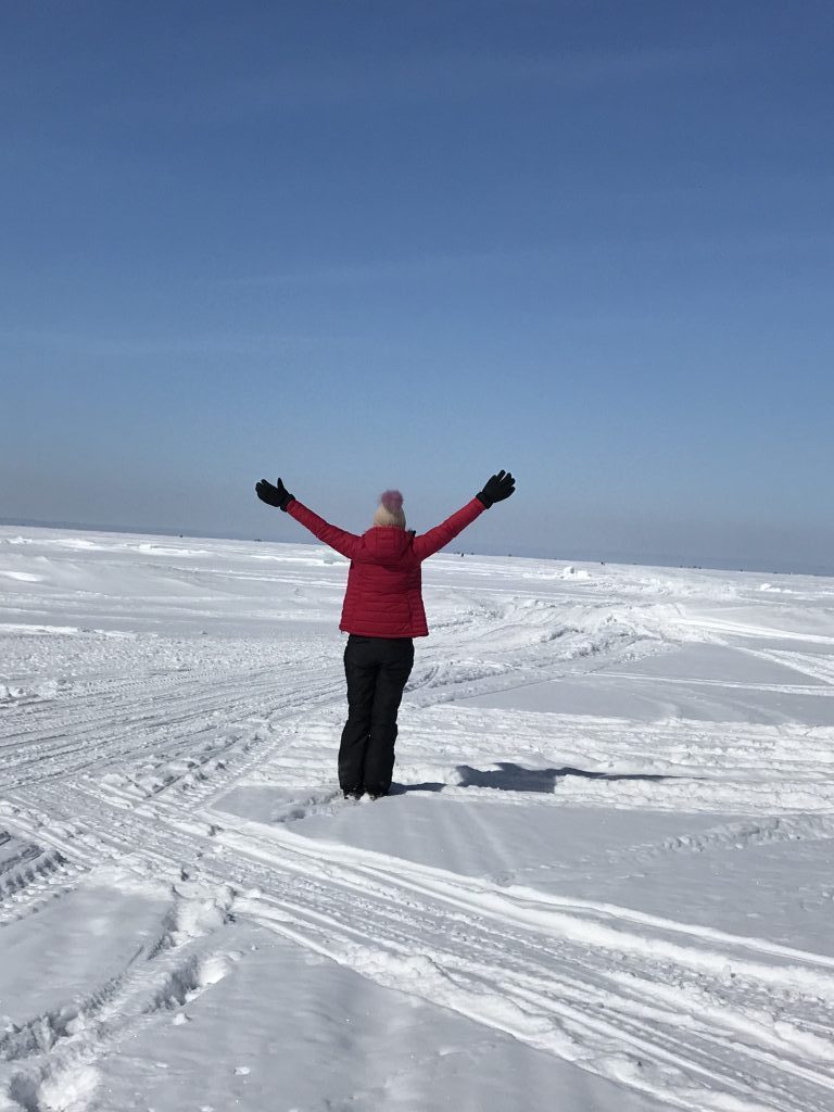lake_simcoe_lady_standing_on_snow_outstretched_arms