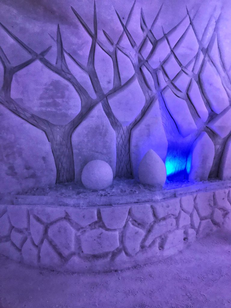 Purple_lit_trees_sculpted_into_snowy_walls_of_hotel-de_glace_quebec_2019