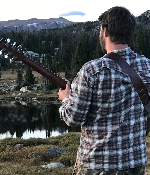 group travel Austin adventures tour guide playing guitar on beartooth pass Montana