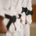 karate black belts standing four in a row with white uniforms on