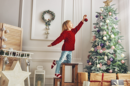 christmas_tree_girl_standing_on_chair_to_reach_tree