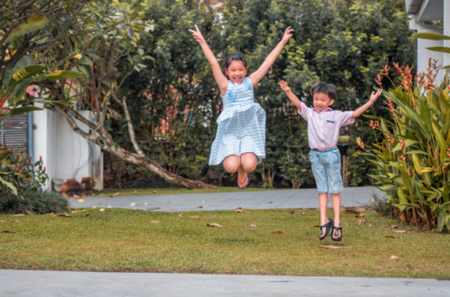 kids_jumping_in_summer_on_front_lawn